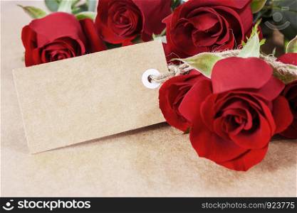 Red roses with blank paper tag on brown paper