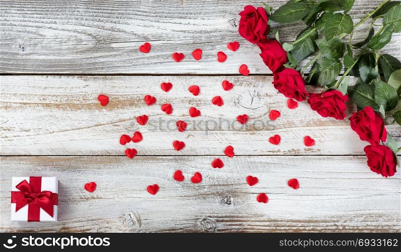 Red roses with gift and decorative hearts for Valentines Day