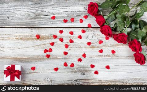 Red roses with gift and decorative hearts for Valentines Day