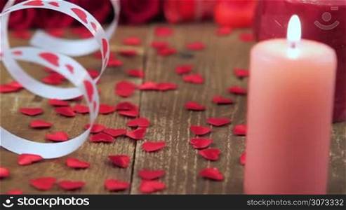 Red roses with gift box and candles on wooden background. Valentines day concept. Love and romance.