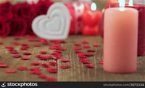 Red roses with heart shape and candles on wooden background. Valentines day concept. Love and romance.