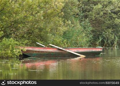 Red rowing boat on lake in the Netherlands