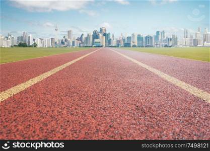 Red running track with city background .