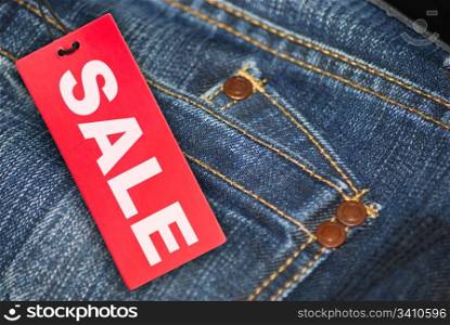 Red Sale Sign With Jeans in Background