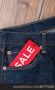 Red Sale Tag With Sale Sign in Pocket of Blue Jeans - With Copyspace