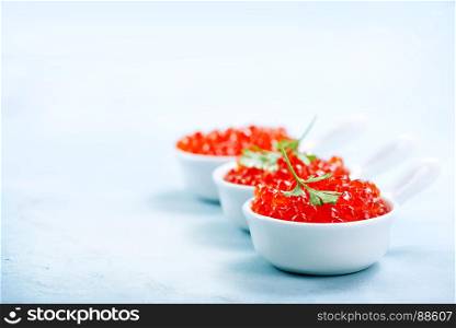 red salmon caviar in bowls and on a table