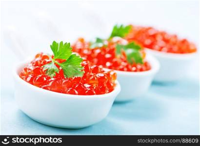 red salmon caviar in bowls and on a table