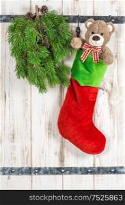 Red Santas hat, Teddy Bear and green pine tree branch. Vintage style christmas decoration