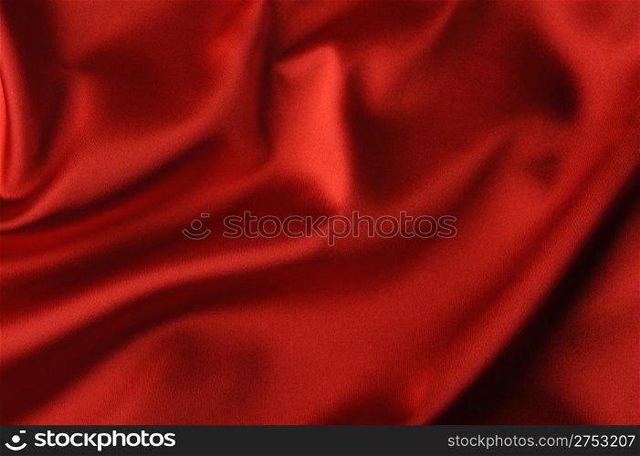 red satin background. A satiny fabric with beautiful light-shadow waves