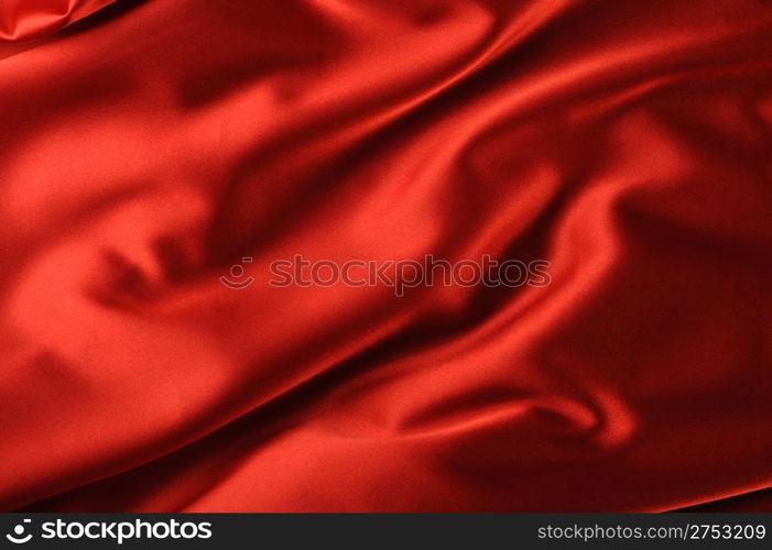 red satin background. A satiny fabric with beautiful light-shadow waves