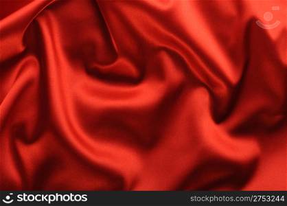red satin background. A satiny fabric with beautiful light-shadow waves