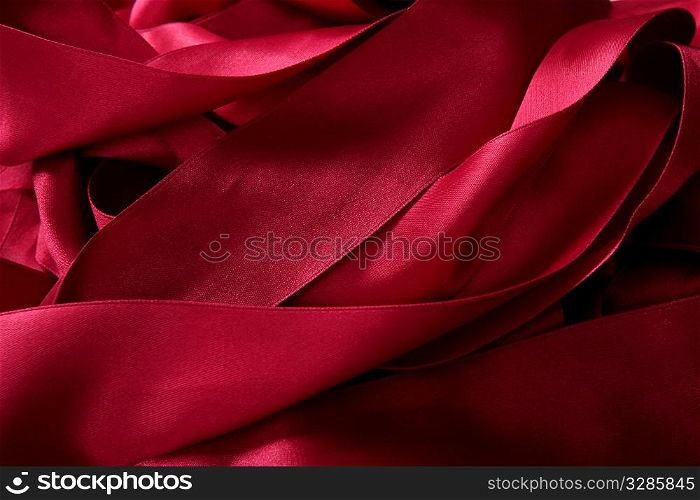 Red satin ribbons in a messy mess texture background