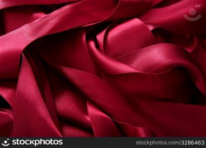 Red satin ribbons in a messy mess texture background