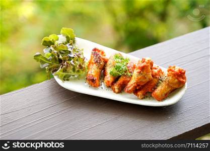 Red sauce grilled Chicken Wings with green beatiful bokeh background