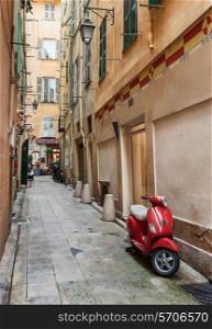 Red scooter on the old narrow street in Nice, France