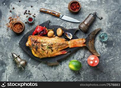 Red sea bass baked with mushrooms and red pepper.Fish in roasted vegetables. Roasted red perch and vegetables