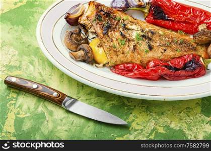 Red sea bass baked with mushrooms and red pepper.Fish in roasted vegetables.Healthy food. Roasted red perch and vegetables