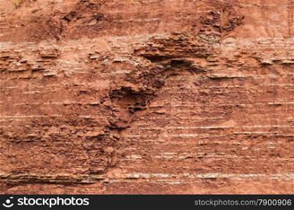 Red sedimentary clay background layers eroding.