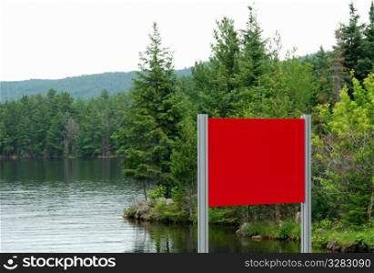 Red sign in natural lake environment.