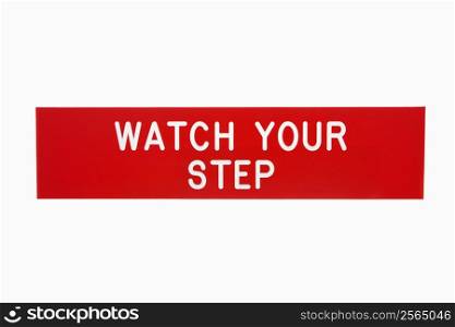 Red sign reading watch your step against white background.