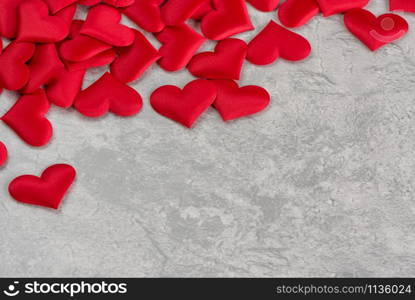 Red silk hearts are on gray ctone surface. Background for Valentine&rsquo;s Day ore wedding composition with copy space