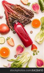 Red smoothie bottle with healthy fruits and vegetables ingredients on white desk background, top view, flat lay, vertical. Healthy clean and detox, weight loss dieting or fasting food concept