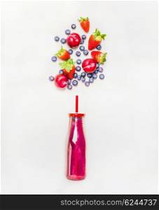 Red smoothie drink in bottle with straw and fruits berries ingredients on white wooden background, top view