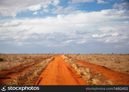 Red soil way, blue sky with clouds, scenery of Kenya