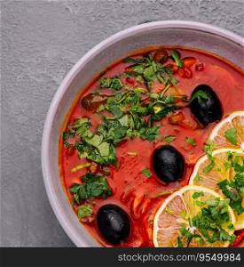 red soup Solyanka, with sausage, olives and lemon