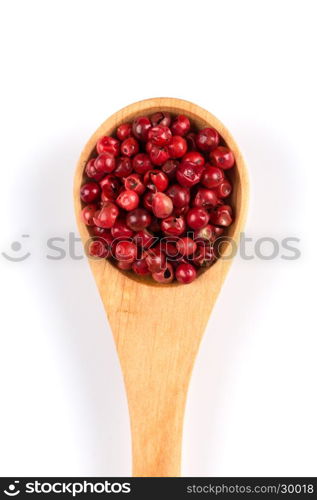 red spice pepper peppercorns in a spoon over white