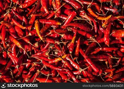 Red spicy chili peppers at asian market close up texture background