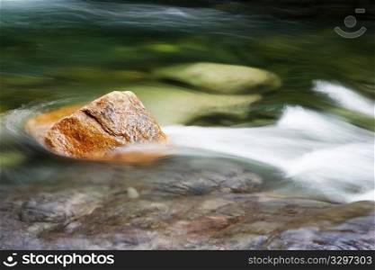 Red stone in a mountain flowing stream