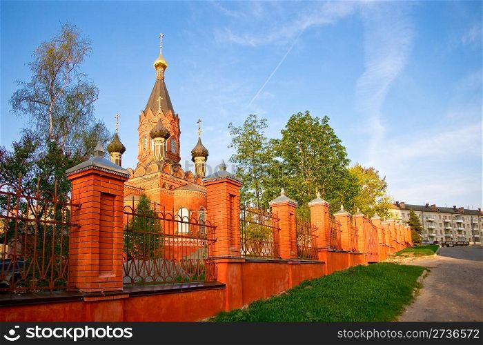 Red stone orthodox church with black cupolas, Bryansk region, Russia