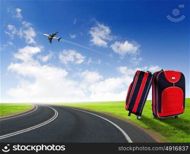 Red suitcase and plane in the blue sky above