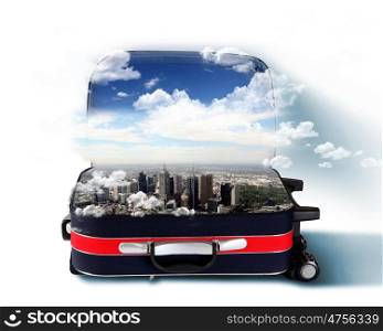 Red suitcase with city on the horizon and blue sky inside