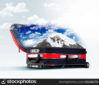 Red suitcase with mountains covered with snow inside