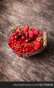 Red summer fruits in metal basket on the table