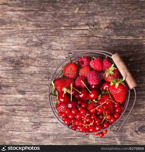Red summer fruits in metal basket on the table
