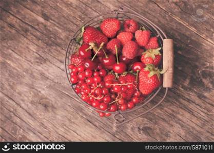Red summer fruits in metal basket on the table. Red summer fruits