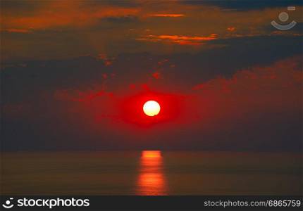 Red sunrise with sun track on sea