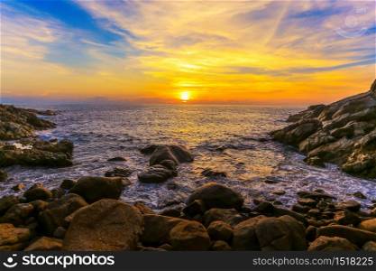 Red sunset at the rocky sea shore
