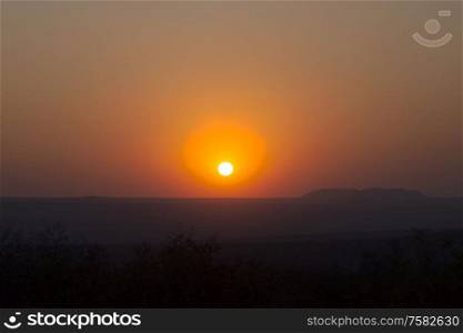 Red sunset over a large area with hills and cliffs in the indian summer
