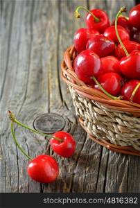 red sweet cherries in a basket on old wood