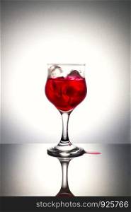 Red syrup on ice with gray background.Used color tool for color tone.