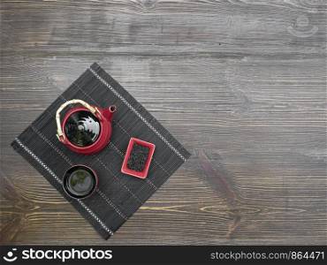 Red tea set on a wooden table. Red teapot, cup and chinese tea. Top view with copy space