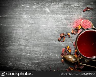Red tea with pomegranate. On a black wooden background.. Red tea with pomegranate.