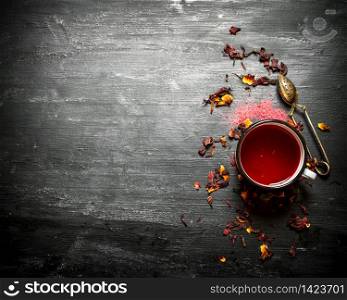 Red tea with pomegranate. On a black wooden background.. Red tea with pomegranate.