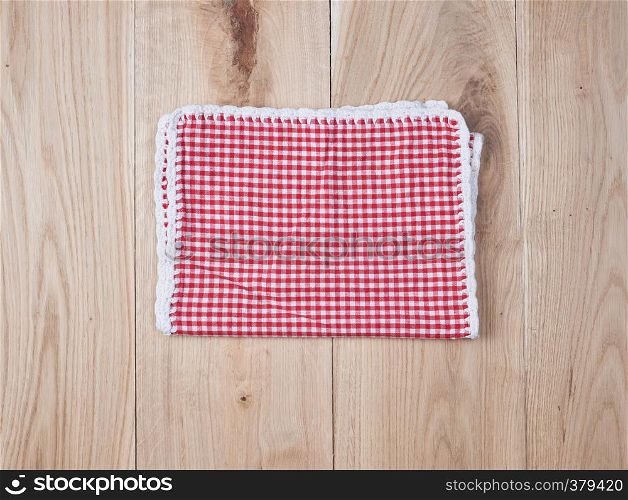 red textile towel in a white cell on a wooden background, copy space