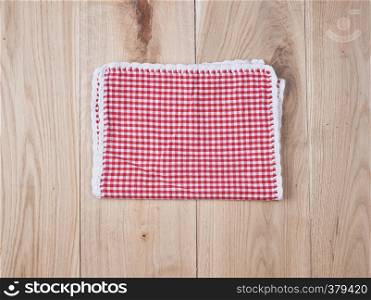 red textile towel in a white cell on a wooden background, copy space
