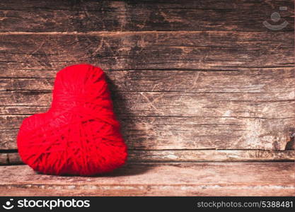 Red thread heart over old shabby background. Valentine concept